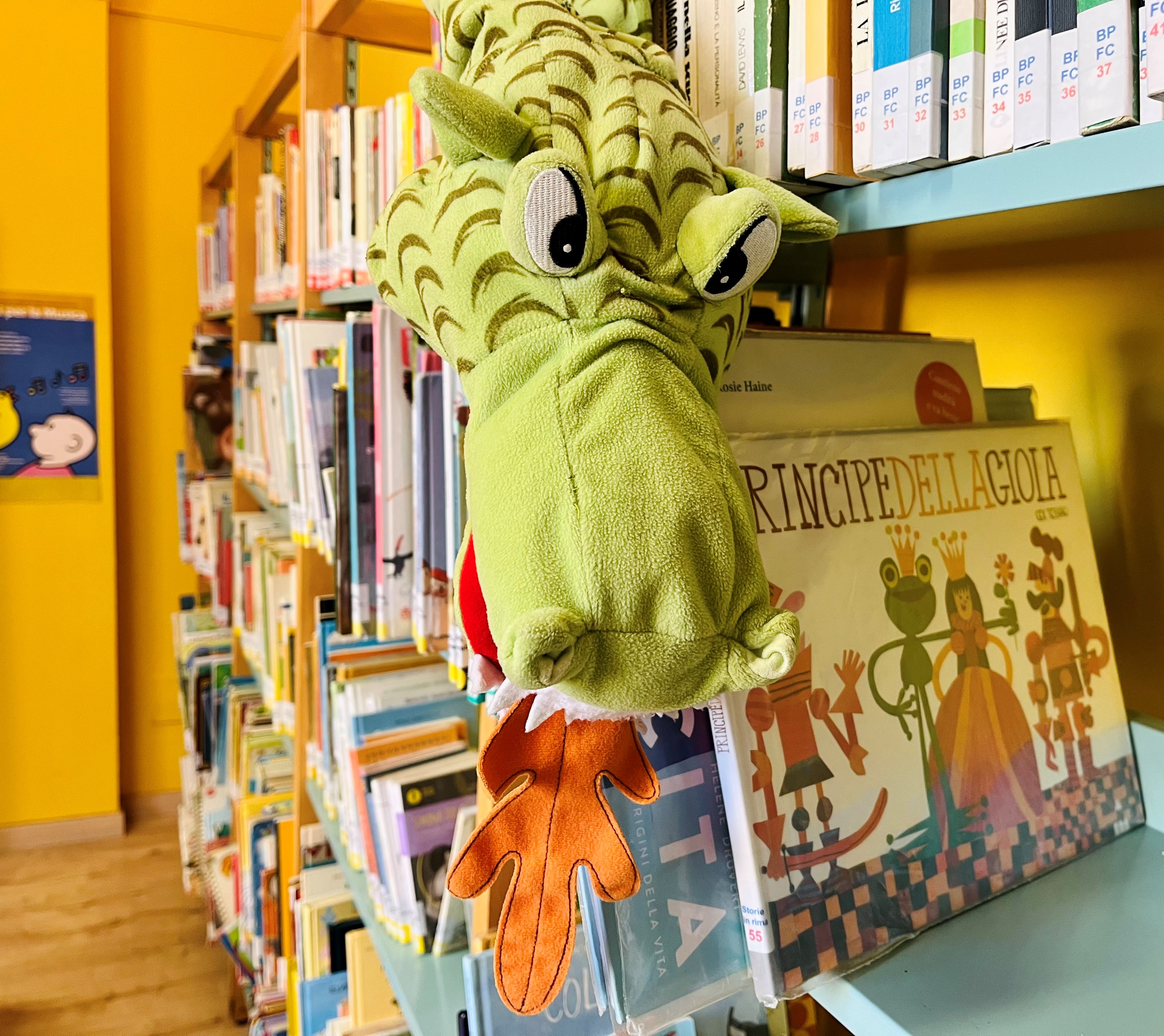 Scaffale di libri con peluche di drago